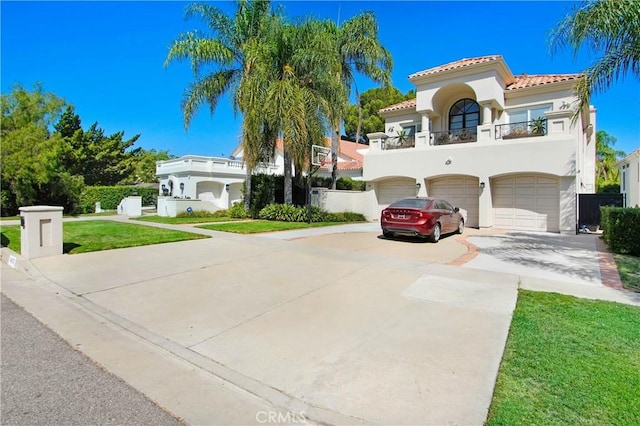 mediterranean / spanish-style home with a balcony, a garage, and a front lawn