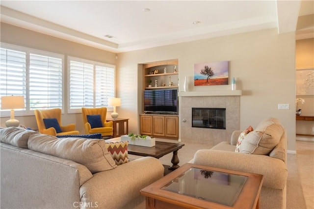 living room featuring built in features and a tile fireplace