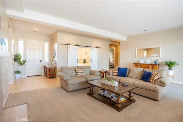 living room with a barn door and light colored carpet