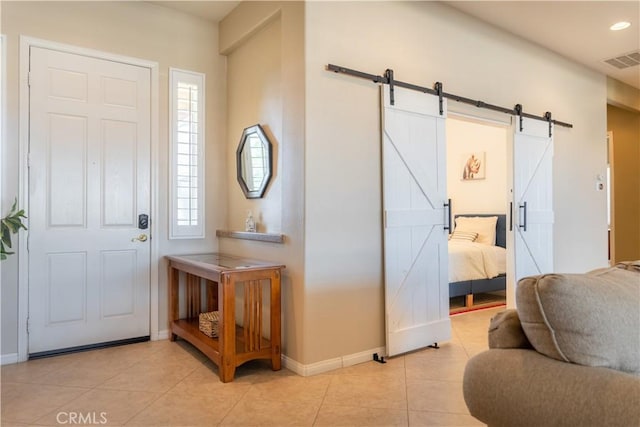 foyer with a barn door and light tile patterned floors