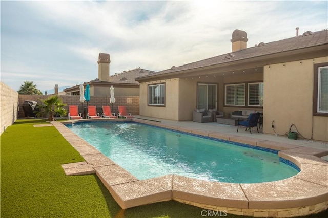 rear view of house featuring an outdoor living space, a fenced in pool, a patio area, and a lawn