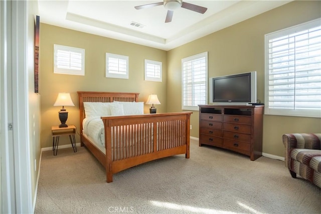 bedroom with light carpet, multiple windows, and ceiling fan