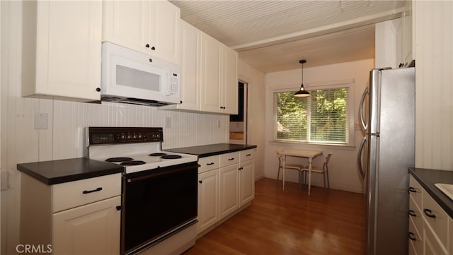 kitchen featuring white appliances, dark hardwood / wood-style flooring, pendant lighting, and white cabinets