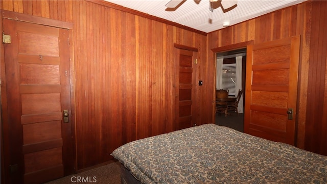 bedroom with wooden walls and ceiling fan