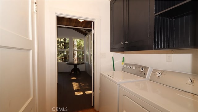 laundry area with hardwood / wood-style flooring, washer and clothes dryer, and cabinets