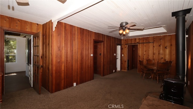 interior space featuring wooden walls and dark colored carpet