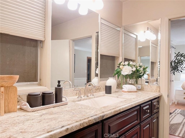 bathroom featuring wood-type flooring, vanity, and ornamental molding