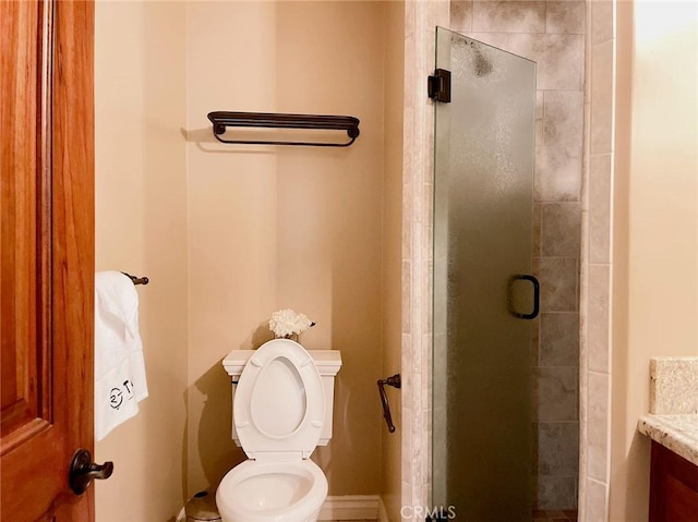 bathroom featuring toilet, an enclosed shower, and vanity