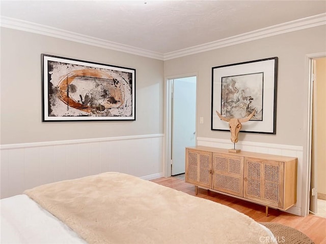 bedroom featuring crown molding and light hardwood / wood-style floors