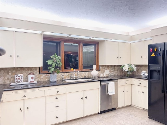 kitchen with backsplash, black fridge, dishwasher, and sink