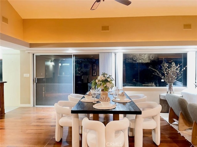 dining space featuring wood-type flooring and lofted ceiling