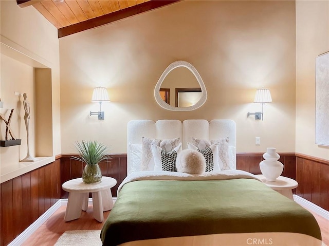 bedroom with hardwood / wood-style floors, lofted ceiling with beams, wooden walls, and wooden ceiling