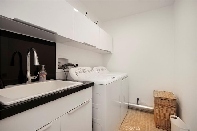 laundry area featuring cabinets, sink, and washer and clothes dryer