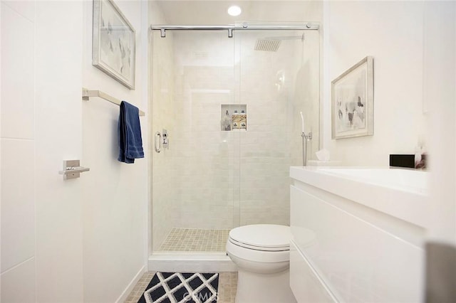 bathroom with tile patterned floors, toilet, and a shower with door