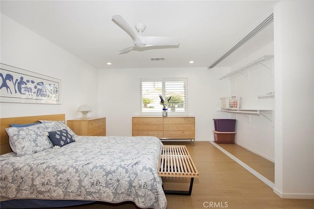 bedroom featuring wood-type flooring, a walk in closet, a closet, and ceiling fan