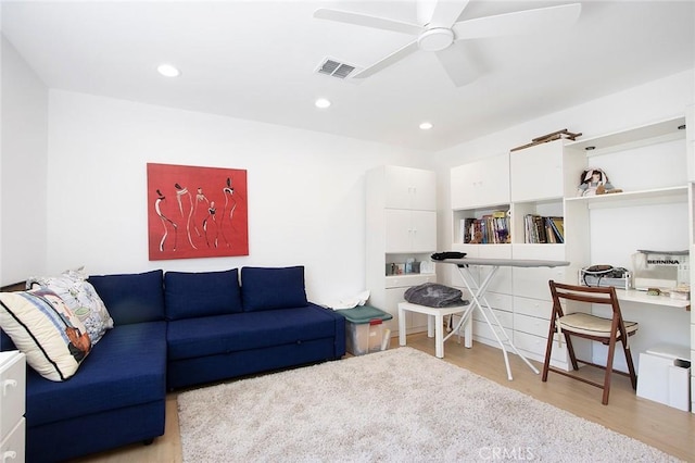 living room featuring ceiling fan and light hardwood / wood-style flooring