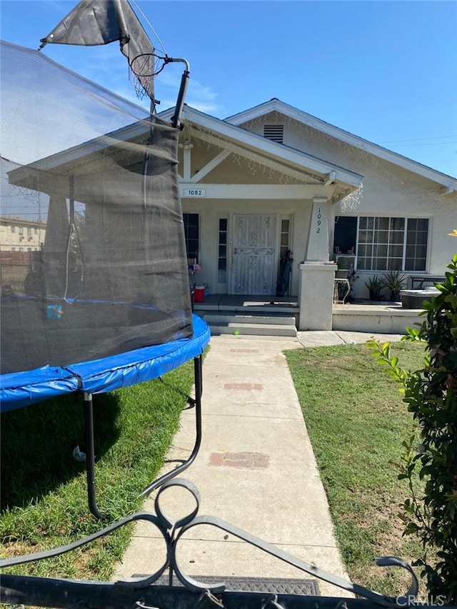 view of front of home featuring a trampoline and a front lawn