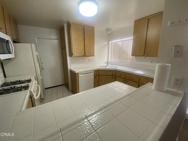 kitchen featuring tile patterned flooring, tile countertops, kitchen peninsula, sink, and white appliances