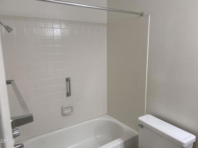 bathroom with tiled shower / bath combo and toilet