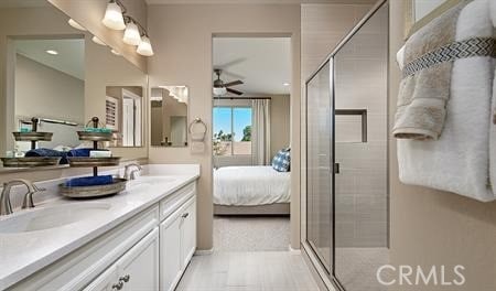 bathroom with vanity, ceiling fan, and an enclosed shower