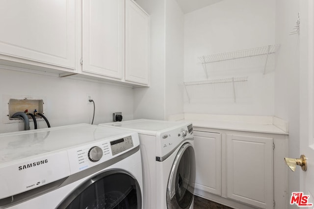 laundry room with washer and clothes dryer and cabinets