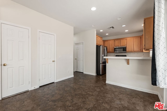 kitchen featuring a breakfast bar, appliances with stainless steel finishes, and kitchen peninsula