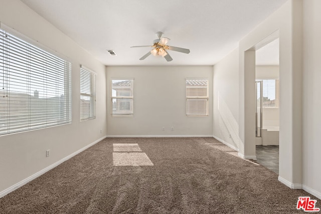 carpeted spare room featuring ceiling fan