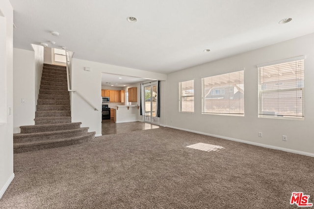 unfurnished living room with dark carpet