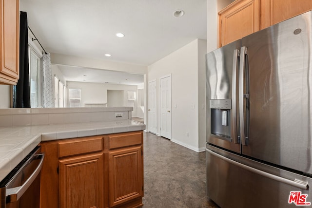 kitchen with appliances with stainless steel finishes and tile counters