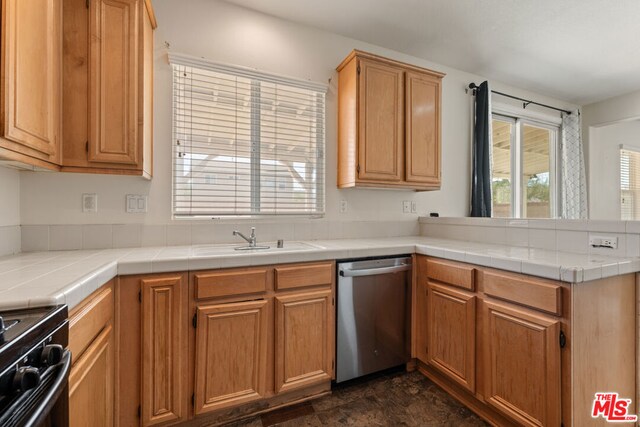 kitchen with tile counters, black range with electric stovetop, sink, kitchen peninsula, and stainless steel dishwasher