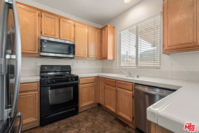 kitchen featuring sink, appliances with stainless steel finishes, and tile counters