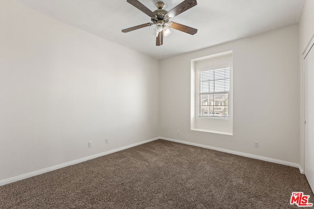 carpeted spare room with ceiling fan