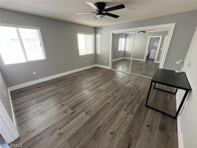 interior space featuring dark hardwood / wood-style flooring, ceiling fan, and a closet