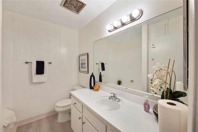 bathroom featuring hardwood / wood-style floors, vanity, and toilet