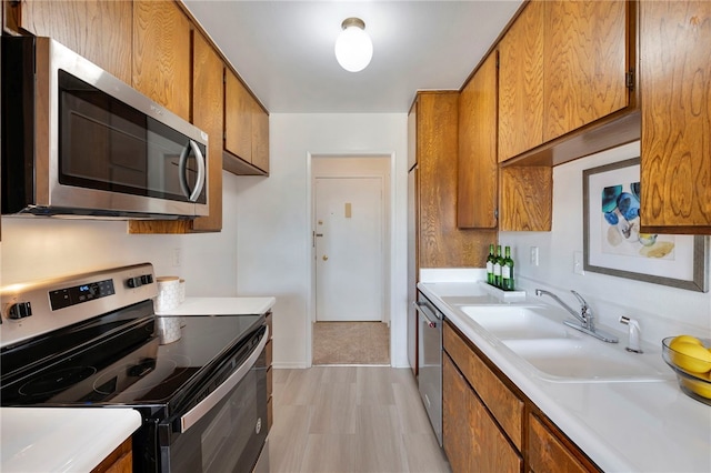 kitchen with stainless steel appliances, light hardwood / wood-style floors, and sink