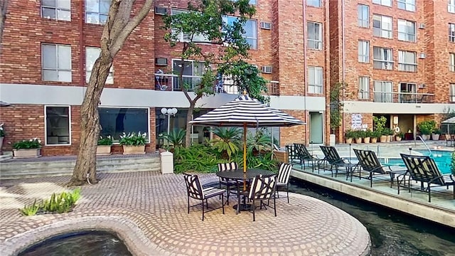 view of property's community featuring a swimming pool and a patio