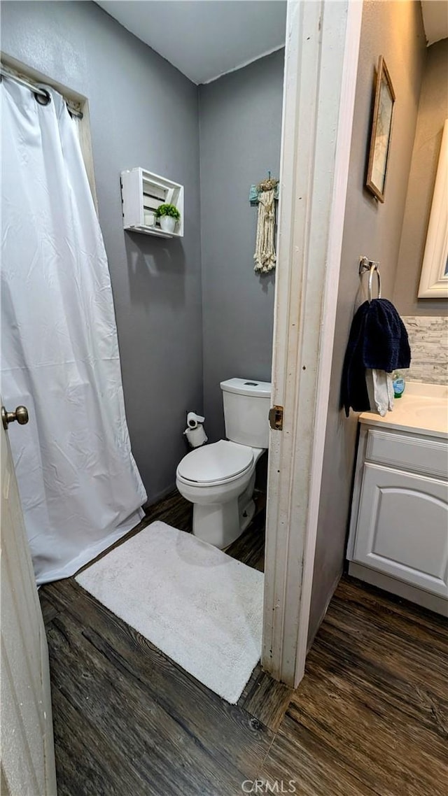 bathroom with toilet, vanity, and hardwood / wood-style flooring