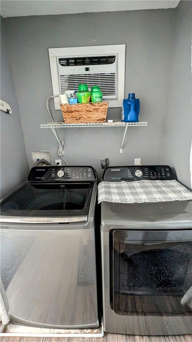 clothes washing area featuring washing machine and dryer and wood-type flooring