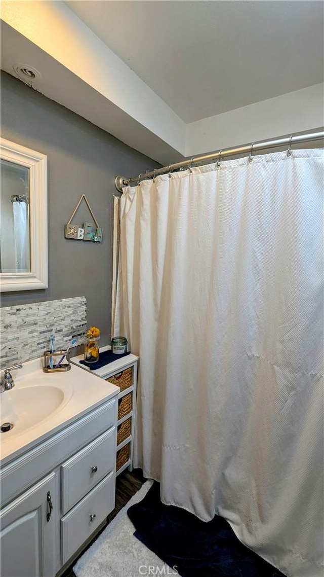 bathroom featuring vanity and tasteful backsplash