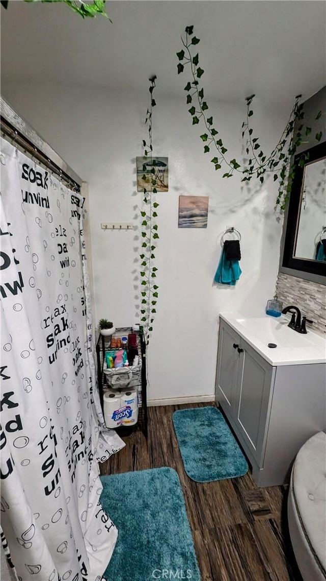 bathroom with vanity, toilet, and wood-type flooring