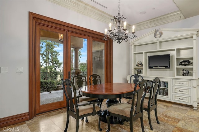 dining room with built in shelves, crown molding, and a chandelier