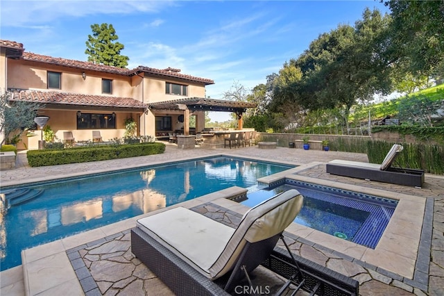 view of pool with a pergola, an outdoor bar, a patio, and an in ground hot tub