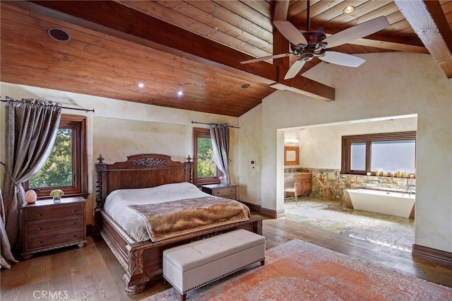 bedroom featuring ceiling fan, wooden ceiling, ensuite bath, and vaulted ceiling with beams