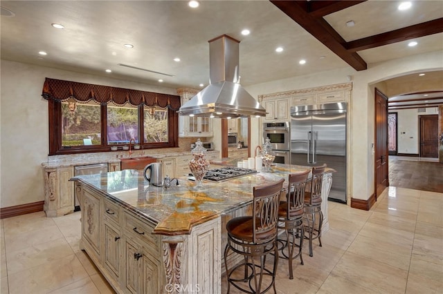 kitchen with sink, light stone countertops, appliances with stainless steel finishes, a large island, and island range hood