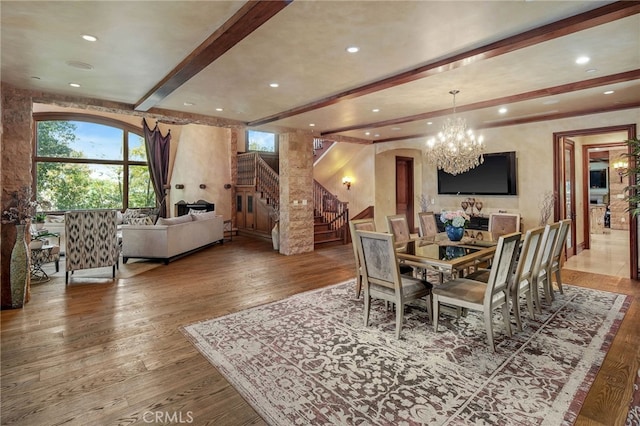 dining area featuring beam ceiling, a notable chandelier, and hardwood / wood-style flooring