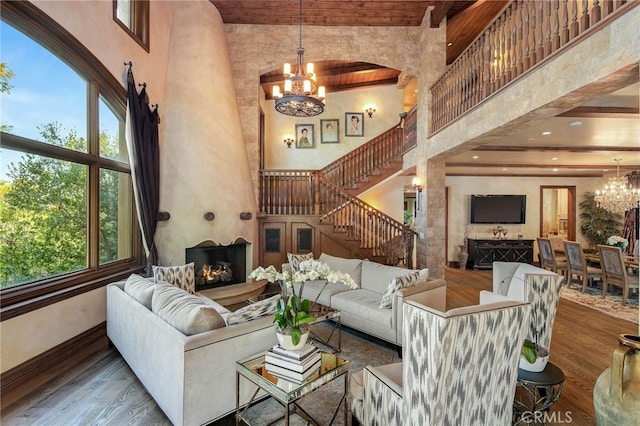 living room with a large fireplace, dark hardwood / wood-style flooring, plenty of natural light, and a high ceiling