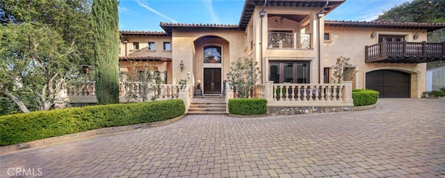 mediterranean / spanish home featuring a balcony and a garage