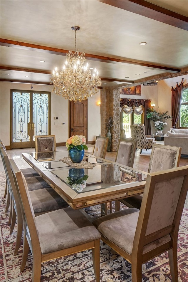 dining area with a chandelier, a healthy amount of sunlight, french doors, and beamed ceiling