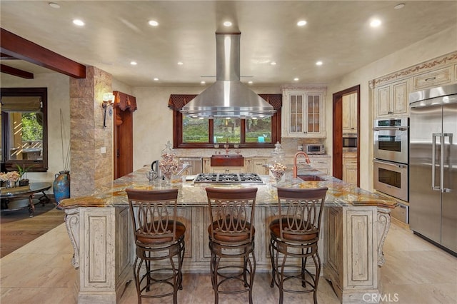 kitchen featuring sink, a kitchen bar, a spacious island, and built in appliances