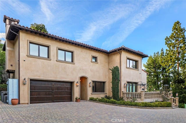 mediterranean / spanish-style home with a garage